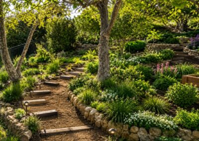 Custom landscaping service featuring natural stone borders, garden pathways, and drought-tolerant landscape design in Ventura County